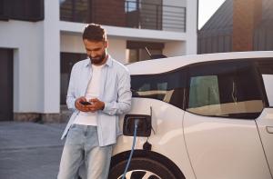 Homme entrain de charger sa voiture électrique à domicile