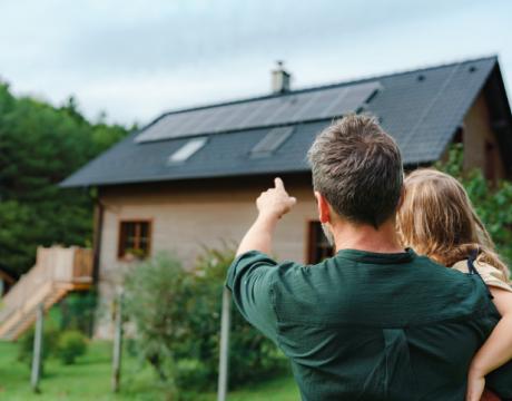 famille devant maison avec des panneaux solaires