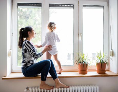 femme et enfant dans une maison au dessus d'un radiateur